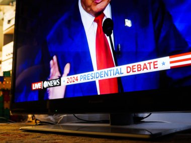Paris, Fransa - 11 Eylül 2024: Sessiz bir oturma odasında yalnız bir televizyon Donald Trump 'ın yükselen elini ve 2024 Başkanlık Müzakeresi başlığını izleyicisi olmayan bir siyasi yayın sırasında sergiliyor