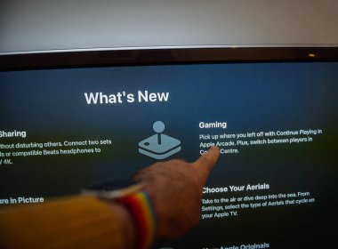Frankfurt, Almanya - 20 Ekim 2020: Apple TV 'deki Oyun özelliğini gösteren bir parmağın yakın çekimi Yeni Bölüm, Apple Arcade ve oyuncunun loş ışıklandırma altında seçenekleri değiştirmesi