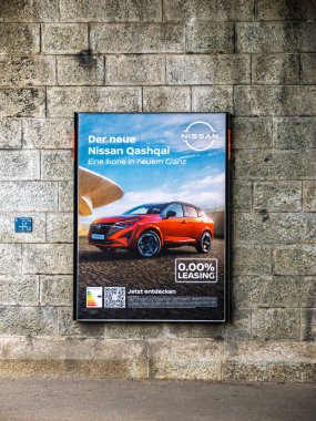 Basel, Switzerland - Sep 8, 2024: Nissan Qashqai advertisement on a stone wall in Basel, Switzerland, promoting 0.00 percent leasing with a bold display of the red SUV and informational text in German clipart