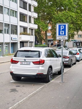 Basel, İsviçre - 8 Eylül 2024: Basel, İsviçre 'de bir caddeye park etmiş arabalar, 90 dakikalık maksimum zaman limiti olan, konut ve ticari binalarla çevrili bir park yeri.