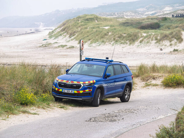 Харделот, Франция - 18 августа 2023 года: Французская жандармерия полицейский автомобиль, припаркованный на прибрежной дорожке недалеко от песчаных дюн Хардело, Франция, с туманным пляжным пейзажем на заднем плане