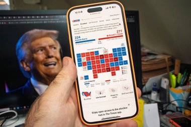 Paris, Fransa - 6 Kasım 2024: Bir akıllı telefon, Trump 'ın Harris' i yönettiği 2024 seçim haritasını Donald Trump 'ın bir görüntüsünü gösteren bir arka plan ekranında gösteriyor