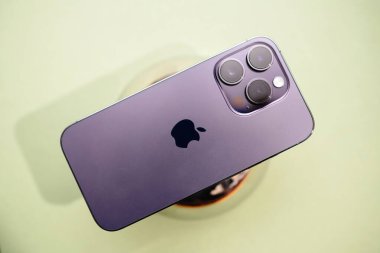 Frankfurt, Almanya - 6 Kasım 2023: Deep Purple 'da iPhone 14 Pro Max' in yakın plan çekimi, üç kamera lensi ve Apple logosu ile gösterilen gösterişli arka plan