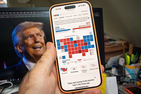 Paris, France - Nov 6, 2024: A smartphone shows the 2024 election map with Trump leading Harris, set against a background screen displaying an image of Donald Trump