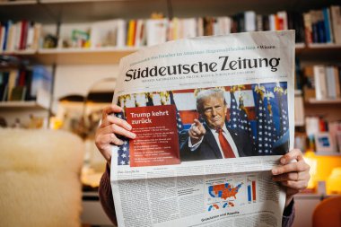 Paris, Fransa - 7 Kasım 2024: Alman Suddeutsche Zeitung gazetesini okuyan kadın, Donald Trump 'ın son ABD seçimlerinde iktidara dönüşüyle ilgili manşet attı