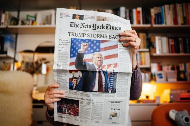 Paris, Fransa - 7 Kasım 2024: The New York Times 'ı sıcak bir oturma odasında tutan kişi, manşet Trump Storms Back' in Donald Trump 'ın siyasi dönüşünü konu alıyor