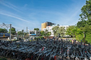 Alkmaar, Hollanda - 29 Ağustos 2024: Arka planda çok sayıda park halindeki bisiklet ve tren yolu bulunan Alkmaar tren istasyonunun geniş görüş alanı