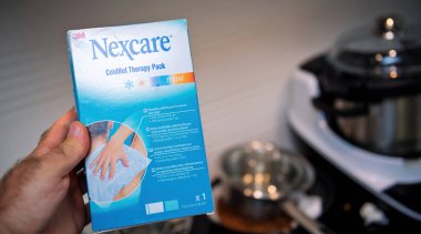 Frankfurt, Almanya - 22 Ağustos 2024: Nexcare ColdHot Therapy paketinin el ele tutulması, ev kullanımı için soğuk ve sıcak ağrı kesici olanakları vurgulanıyor