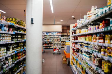 Haarlem, Hollanda - 30 Ağustos 2024: Personel sabah erken saatlerde mağazayı ziyaretçilere hazırlarken, karton geri dönüşüm için çelik bir kutuya sahip büyük bir Hollanda süpermarketi.