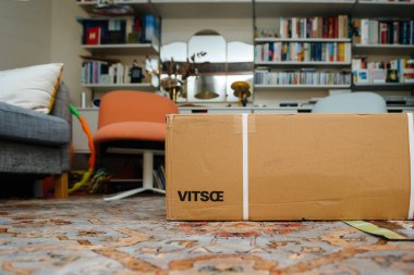 Frankfurt, Almanya - 21 Ağustos 2024: Vitsoe rafları ve karton kutusunda hala boks, modern tasarım ve organizasyonun ön plana çıkarılmasına hazır yeni bir Vitsoe eşyasının yer aldığı bir oturma odası