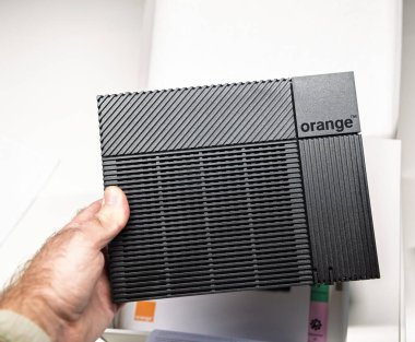 Paris, Fransa - 19 Kasım 2021: Orange Livebox 5 yönlendiricisinin parlak ve kompakt tasarımına yakın plan, modern evler için dokulu siyah kaplamasını ve minimalist markasını sergiliyor