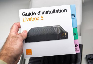 Paris, Fransa - 19 Kasım 2021: Orange Livebox 5 kurulum rehberine yakın plan, internet yönlendiricisini kurmak için temiz ve kullanıcı dostu bir tasarım içeriyor, modern işlevselliğini vurguluyor