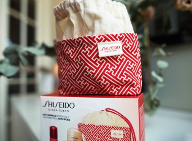 Paris, France - Dec 1, 2024: Shiseido red gift bag and product box with skincare essentials, combining beauty and luxury design for a perfect gift clipart