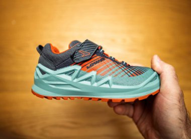 Frankfurt, Almanya - 13 Nisan 2024: Gök mavisi ve turuncu renkli yürüyüş ayakkabıları giyen bir Lowa Çocukları 'nın modern tasarımı, güçlü destek yapısı ve solunabilir materyalinin yan görüntüsü.