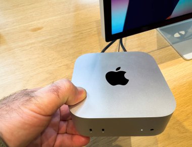 Paris, Fransa - 10 Aralık 2024: M4 silikon çipli yeni Mac Mini 'yi tutan, kompakt tasarımını, USB-C portlarını ve parlak kaplamasını gösteren yakın çekim.