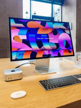 Paris, Fransa - 10 Aralık 2024: M4 silikon çipini içeren yeni Mac Mini canlı bir stüdyo görüntüsü, klavye ve aksesuarlarla eşleştirildi ve Apple Store 'daki parlak ahşap bir masada sergilendi..
