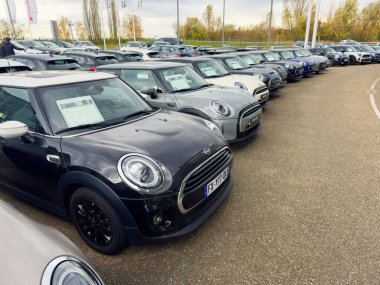 Paris, Fransa - 25 Kasım 2024: Bir araba galerisinde Mini Cooper 'ların ön camlarında satıştan elde edilen bilgilerle çeşitli model ve renkleri sergilemesi.