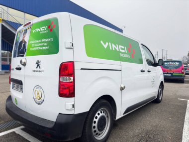 Paris, Fransa - 7 Kasım 2024: Peugeot 'un beyaz bir Vinci tesisi, arka planda diğer araç ve binalarla birlikte çevresel sorumluluk markalaşması sergiliyor..