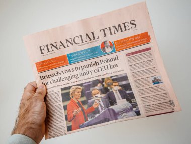 Paris, Fransa - 21 Ekim 2021: 20 Ekim 2021 tarihli Financial Times gazetesini tutan bir el, Polands 'ın AB hukuk sorunlarıyla ilgili olarak Brüksel' in küresel başlıklarıyla ilgili bir başlık attı