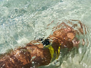 Mallorca, Spain - Jun 29, 2023: Shape of male hand diving swimming in clear Mediterranean Sea sea water with new titanium Apple Watch Ultra Caribbean beach clipart