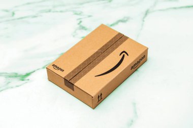 Paris, Fransa - 22 Kasım 2022: Küçük kahverengi Amazon paketi, temiz mermer bir yüzeye yerleştirilmiş, minimal ve çevre dostu ambalajlar sergiliyor..