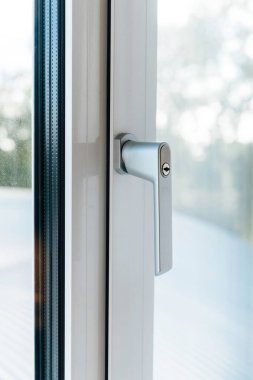 Çift camlı panel tarafından çerçevelenmiş güvenli kilit mekanizması ile parlak gümüş PVC pencere sapı, prim kalitesini ve çağdaş tasarımı vurguluyor.