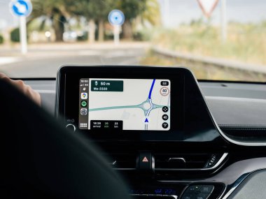 Manacor, İspanya - 6 Haziran 2024: Apple Carplay 'i Apple Haritalarıyla gösteren bir hibrit araba iç mekanı, dolambaçlı bir yolda yol alıyor, modern GPS teknolojisini ve araç içi bilgi işleme sistemlerini vurguluyor