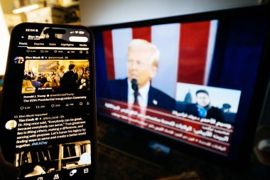 Paris, Fransa - 20 Ocak 2025: Donald Trump 'ın 60. başkanlık yemin törenini canlı TV haberleri ve Elon Musk Twitter hesabından yapılan sosyal medya güncellemeleriyle izlemek.