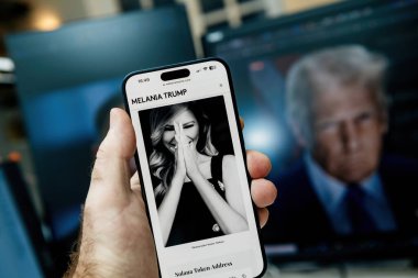 Paris, Fransa - 20 Ocak 2025: Bir el Melania Trump 'ın melaniame.com sitesinden siyah-beyaz bir portresini gösteren bir iPhone tutuyor, metin ve aşağıdaki Solana Token Adresi.