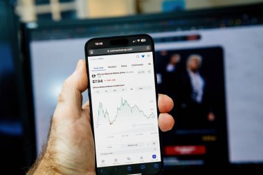 Paris, Fransa - 20 Ocak 2025: Resmî Melania Meme kripto para biriminin fiyat tablosu ile CoinMarketCap web sitesini gösteren bir el, arka planda 7.94 ABD Doları değerinde bir siluet gösteriyor