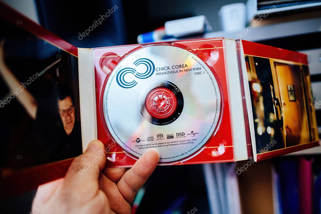 Paris, France - Feb 25, 2024: POV musician fan holding Close-up of a SACD labeled Chick Corea - Rendezvous in New York inside its open jewel case, revealing vivid artwork and details of the disc.