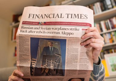Paris, Fransa - 9 Aralık 2024: Financial Times 'ı okuyan bir kişi, isyancıların Halep' i işgal etmesi sonrasında geri saldıran Rus ve Suriye savaş uçaklarıyla ilgili bir başlık attı..