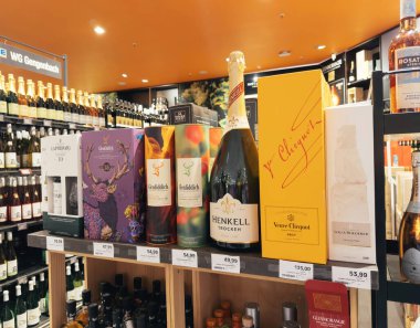 Frankfurt, Almanya - 30 Aralık 2024: İçinde Henkell Trocken, Veuve Clicquot, Glenfiddich ve Louis Roederer 'in de bulunduğu kaliteli şişelerin bulunduğu bir içki dükkanı.