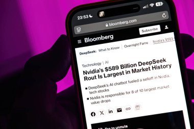 Paris, Fransa - 28 Ocak 2025: Bloomberg 'in Nvidia' nın USD 589 milyar dolarlık piyasa çöküşü hakkındaki makalesini gösteren akıllı telefon ekranı, DeepSeek 'in mor arka plandaki yapay zeka sohbet robotunun tetiklediği tarihteki en büyük olay..