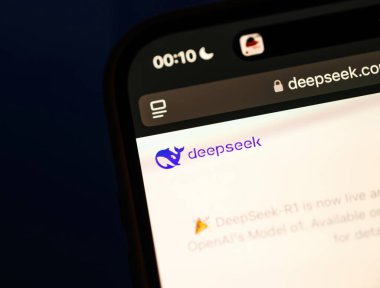 Paris, France - Jan 28, 2025: Smartphone screen showcasing DeepSeek's website header with a logo and announcement about the launch of the R1 model. Tilt-shift effect highlights focus. clipart