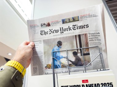 Paris, Fransa - 28 Aralık 2024: The New York Times 'ın uluslararası baskısı, önde gelen küresel manşetler ve bir sağlık çalışanı ve hastayı resmeden bir resim.