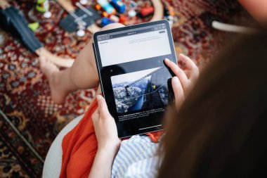 Paris, Fransa - 11 Haziran 2023: Bir tablet üzerinde Apple Vision Pro içeriğine göz atan bir kişi, ekranda manzaralı bir dağ manzarası olan büyüleyici video özelliklerini izliyor.