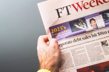 Paris, Fransa - 30 Aralık 2024: Bir kişi FT Weekend 'in bir kopyasını elinde tutuyor, 2025' lerin başlıklarında sinema, tiyatro, müzik ve dans için en iyi biletler ve kurumsal borç satışlarıyla ilgili bir makale yer alıyor