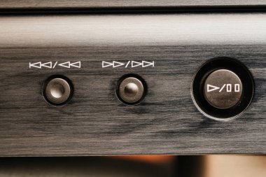 Fırçalanmış bir metal video aygıtının çalma kontrol düğmelerinin yakın plan görüntüsü, parça atlaması, ileri sarma, geri sarma ve durdurma işlevleri.