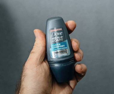 Paris, Fransa - 13 Şubat 2025: Bir kişi tarafsız gri arka plana karşı 48 saatlik koruma ve nemlendirici teknolojiye sahip bir Dove Men artı Clean Comfort rulo terleme önleyici tutuyor.