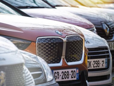 Haguenau, Fransa - 18 Şubat 2025: Ayırt edici kapalı böbrek ızgarası olan elektrikli bir BMW iX, Peugeot ve Renault modelleri de dahil olmak üzere diğer araçların arasına park edilmiştir..