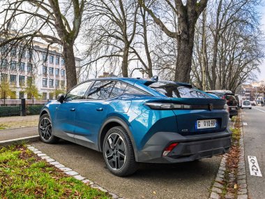Strasbourg, Fransa - 12 Aralık 2022: Fransız plakalı şık mavi bir Peugeot 408 Strasbourg 'da ağaçlık bir cadde boyunca park edilmiş, modern tasarımı ve aerodinamik çizgileri sergilenmektedir.