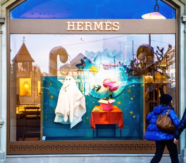 Strasbourg, Fransa - 12 Aralık 2022: Strasbourg 'daki bir Hermes butiği, yayalar lüks mağazanın önünden geçerken hayalet figürlü, yüzen elementli ve canlı dekorlu yaratıcı bir vitrin sergiliyor.