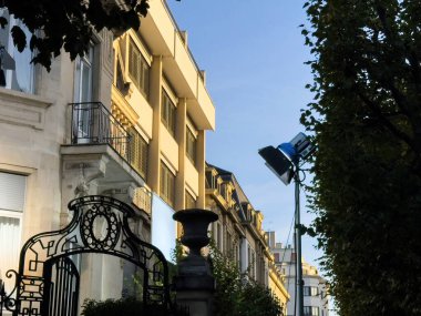Paris, Fransa - 2 Ekim 2023: Paris 'te Arri ışığının klasik bir binanın penceresine doğru parladığı bir film, altın ışığın derin ağaç gölgeleri ve zarif mimari unsurlarla çelişmesi gibi.