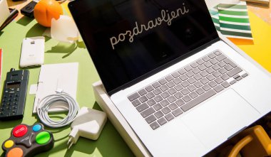 Paris, Fransa - 13 Mart 2025: New MacBook Air M4 dizüstü bilgisayar kurulum ekranı pozdravljeni 'yi şarj eden eski iPhone eski turuncu oyun sahası ve güneşli bir masadaki renk örnekleri gibi aksesuarlar arasında gösteriyor
