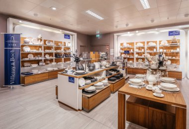 Freiburg, Almanya - 10 Şubat 2025: Villeroy ve Boch masa takımı bölümü porselen tabaklar, kaseler, bardaklar ve bardaklar çağdaş bir perakende galeride düzgünce sergilenmektedir.