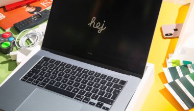 Paris, Fransa - Mar 13, 2025: New MacBook Air M4, Hej 'in renkli yaratıcı masasında aksesuarlar, renk örnekleri, kablo, şarj aleti, iPhone ve parlak ışıklandırmada uzaktan kumanda ile kutusundan çıkarıldı
