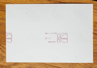 Paris, Fransa - 16 Ocak 2020: Eski bir fotoğrafın arka vitrinleri belli belirsiz izler ve ahşap bir zemin üzerinde beyaz bir arkaplan üzerinde üç farklı kırmızı Kodak işlem pulu.