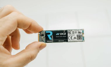 Paris, Fransa - 3 Şubat 2020: Bir kişi Toshiba sağlam bir devlet sürüşüne sahip, tarafsız bir arkaplana karşı kompakt yeşil devre ve ayrıntılı etiketlerini sergiliyor.