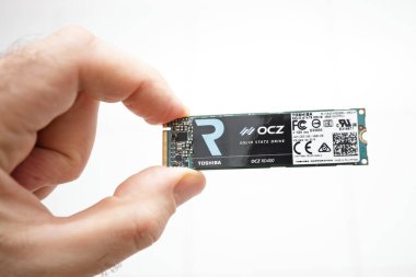 Paris, Fransa - 3 Şubat 2020: Bir el dikkatle bir OCZ RD400 'ü tutuyor, Toshiba markası ve çeşitli sertifika etiketleriyle işaretlenmiş..